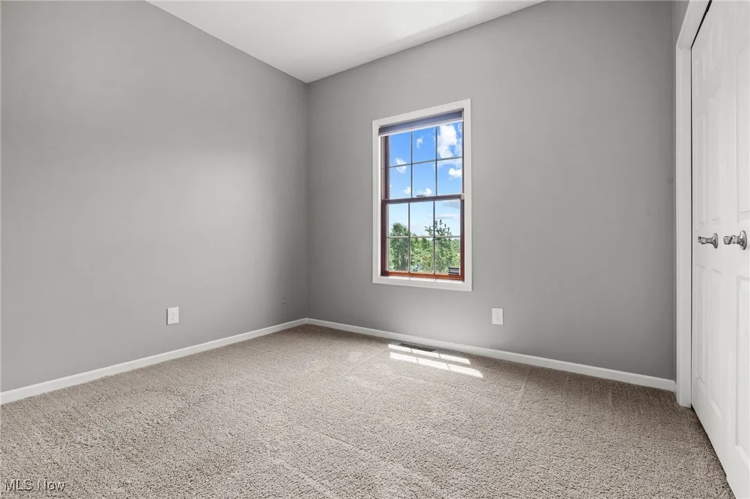 Carpeted empty room featuring baseboards