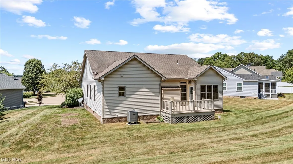 Back of house with a deck, a lawn, crawl space, and a shingled roof