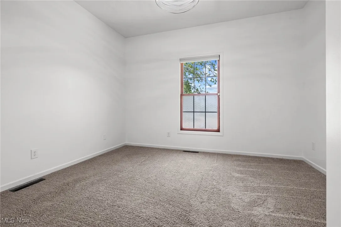 Carpeted spare room with baseboards