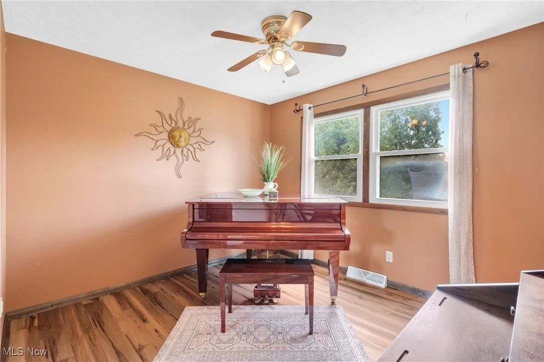 Sitting room featuring light wood-type flooring and ceiling fan