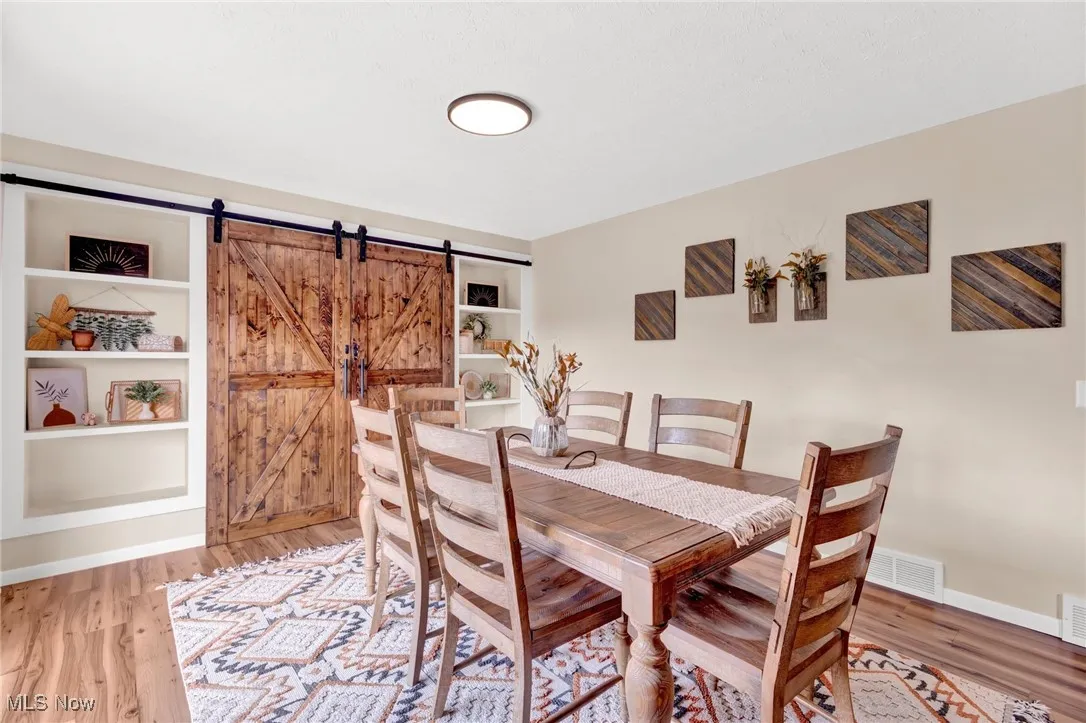 Dining room with a barn door and light wood finished floors