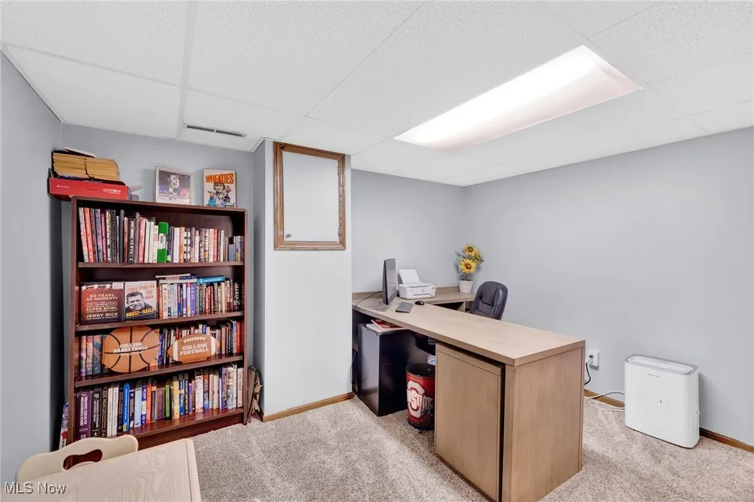 Office with a drop ceiling and light colored carpet