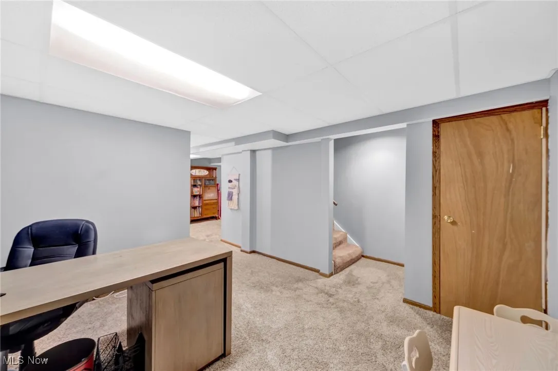 Office space featuring a drop ceiling and light carpet