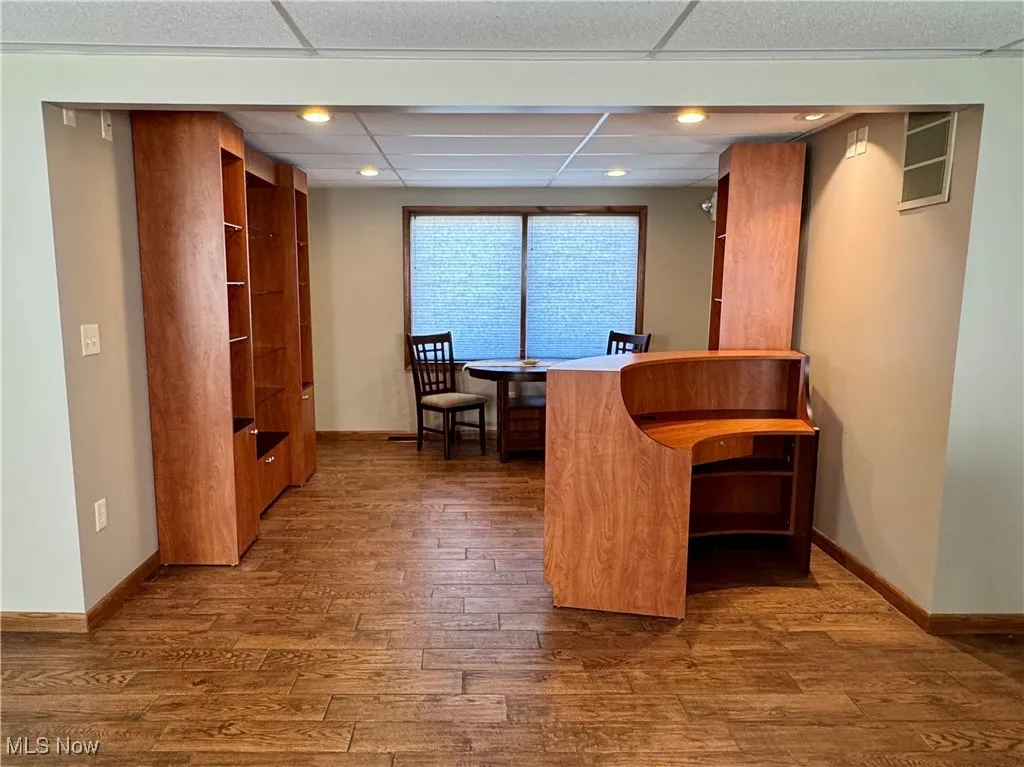 open area featuring wood finished flooring, recessed lighting, and a drop ceiling