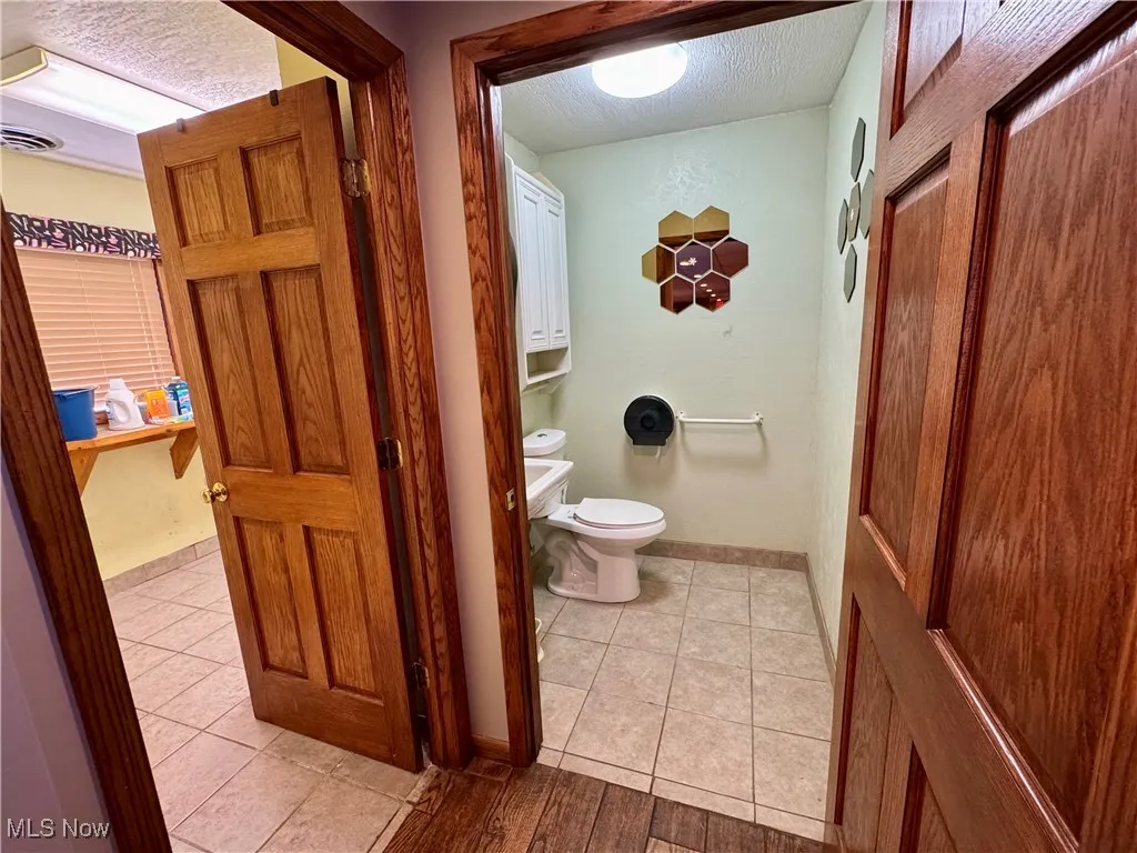 Bathroom with a textured ceiling and tile patterned floors