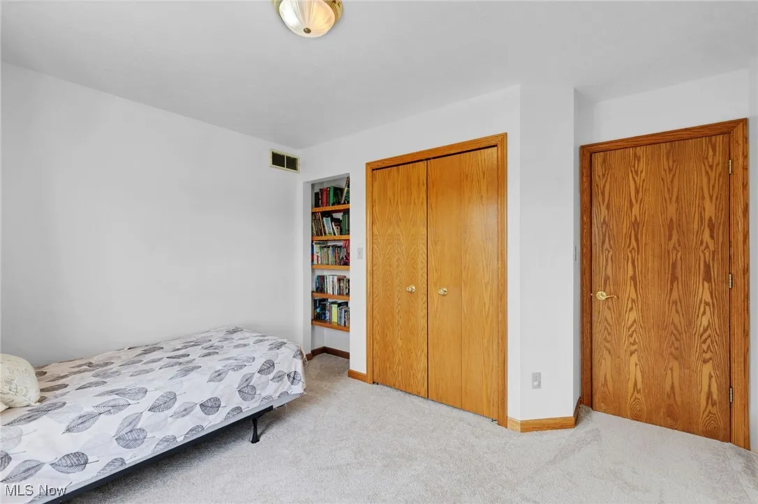 Bedroom featuring carpet and a closet