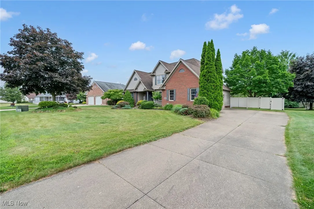 Traditional-style house with concrete driveway, a garage, a gate, and brick siding