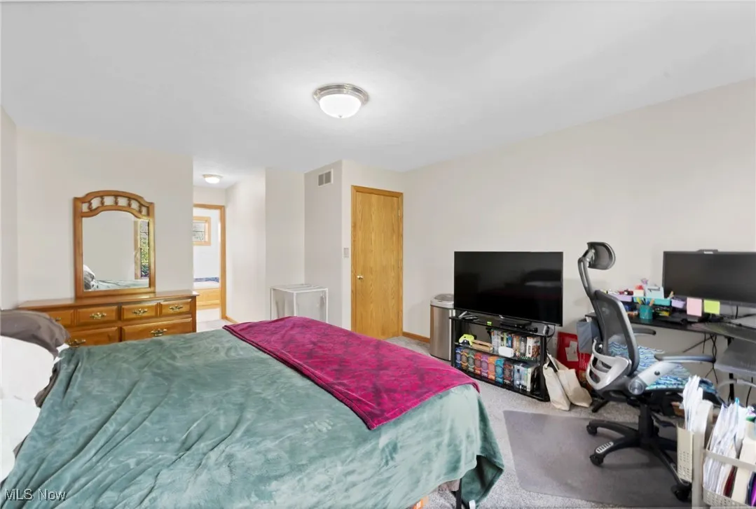 Carpeted bedroom with a desk