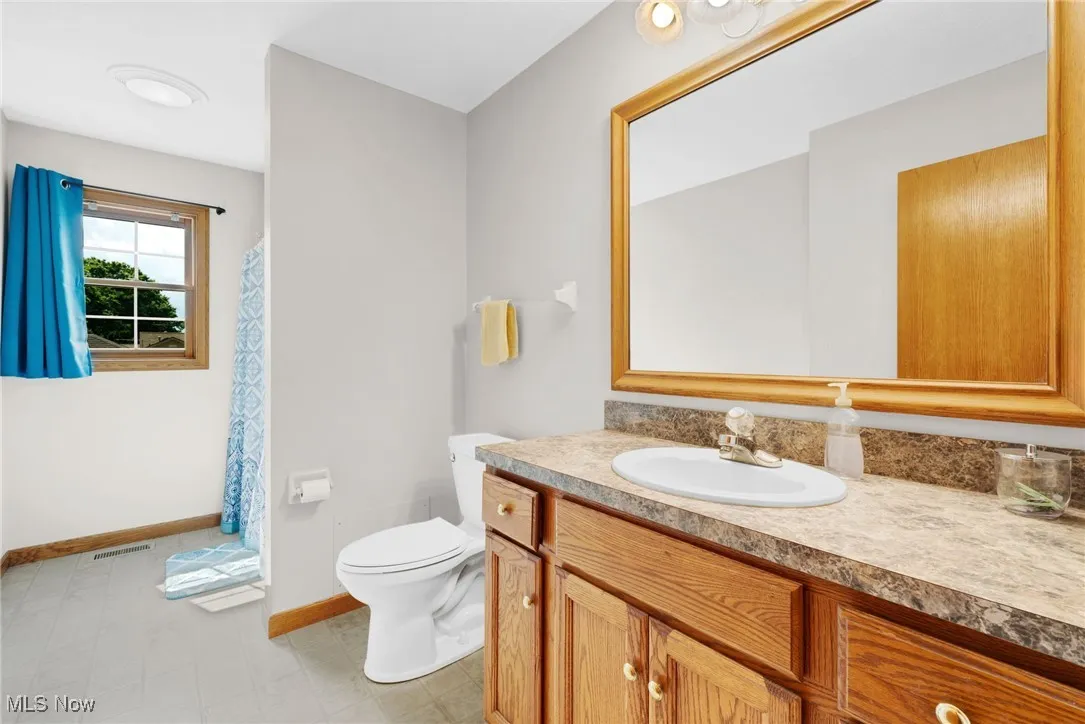 Full bathroom featuring vanity and baseboards