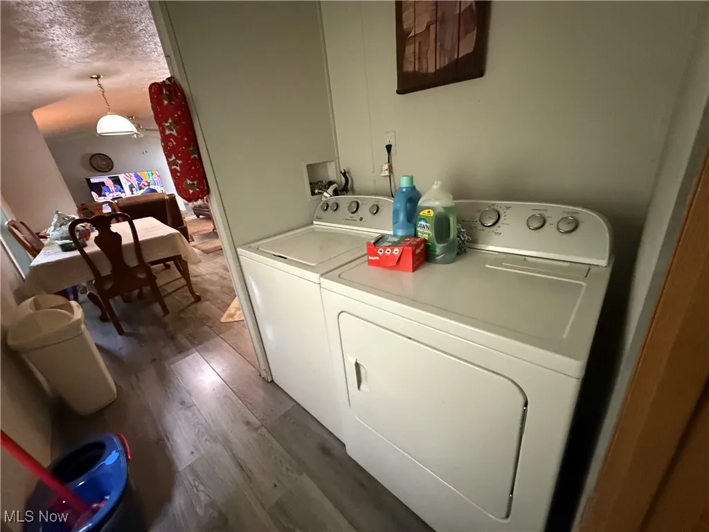 Washroom featuring washer and clothes dryer and wood finished floors