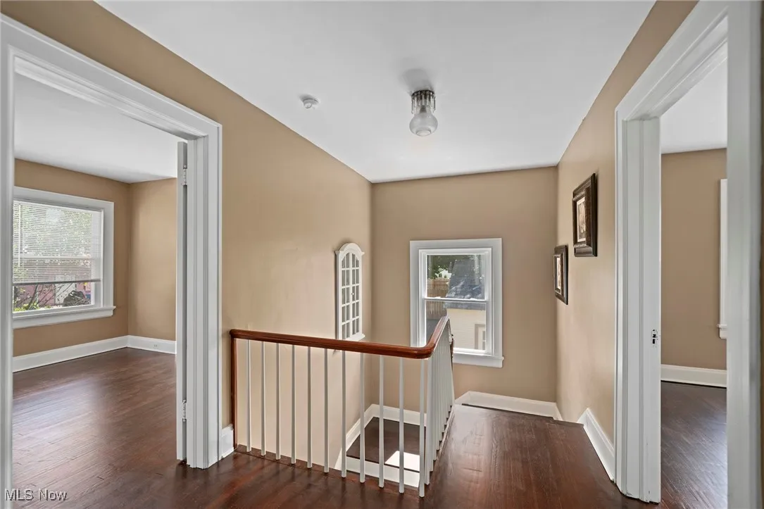Hall with an upstairs landing and dark wood-style floors