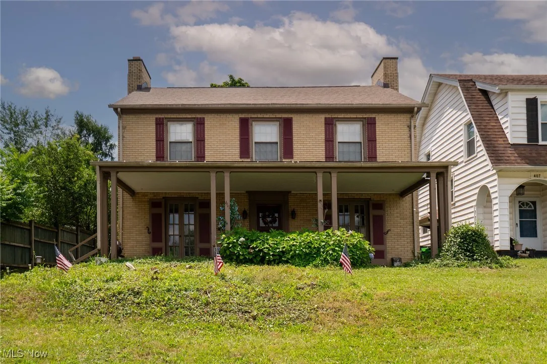 View of front facade with brick siding and a chimney