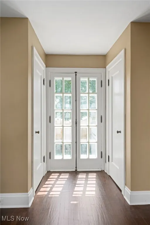 Doorway to outside featuring dark wood-style floors and baseboards