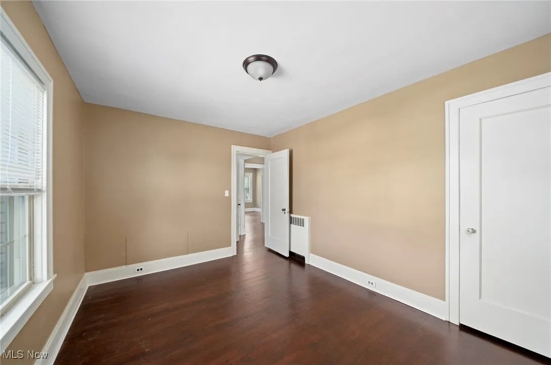 Empty room featuring dark wood finished floors and plenty of natural light