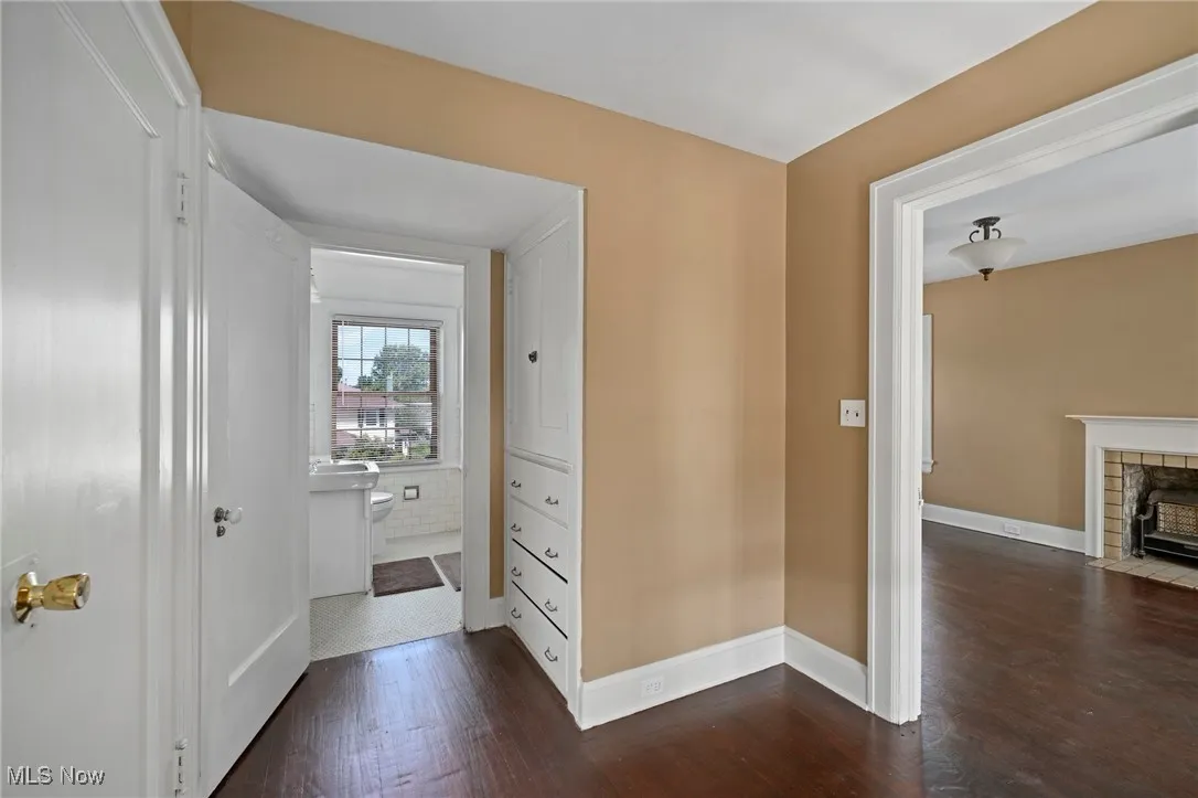 Hallway featuring dark wood finished floors and baseboards
