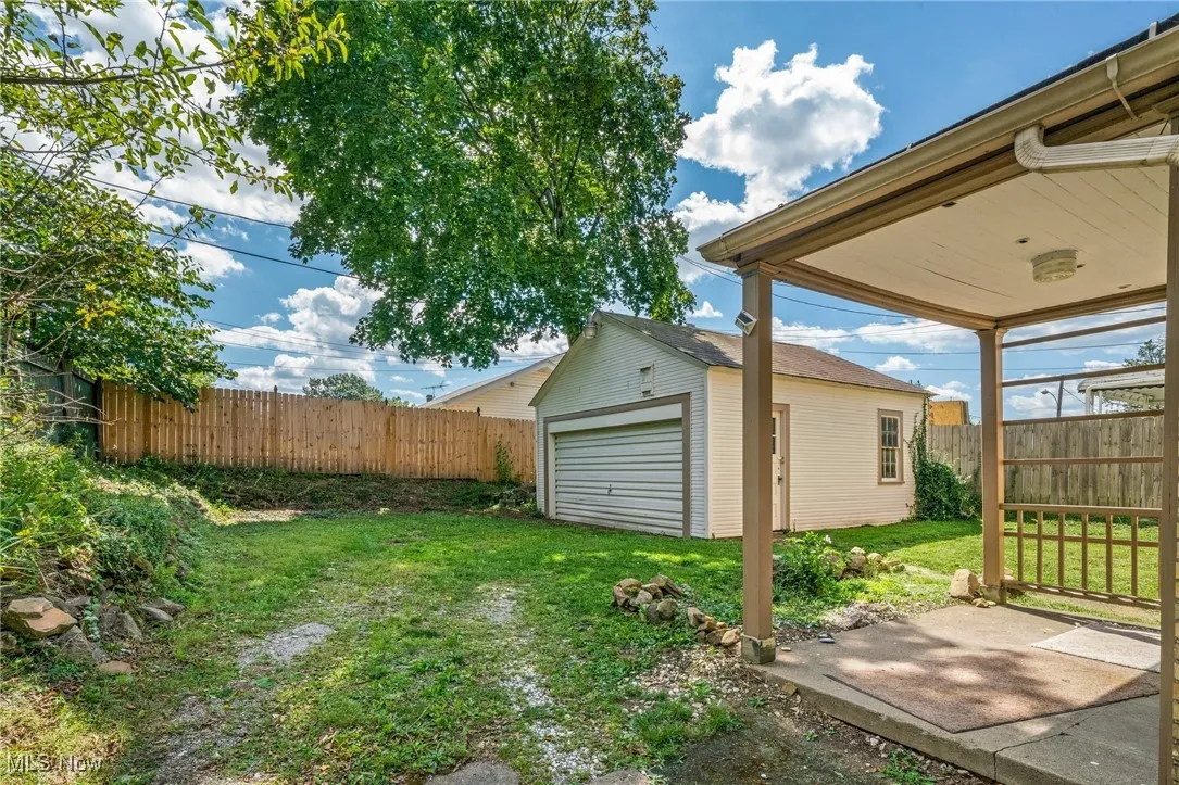 Fenced backyard with an outbuilding and a detached garage