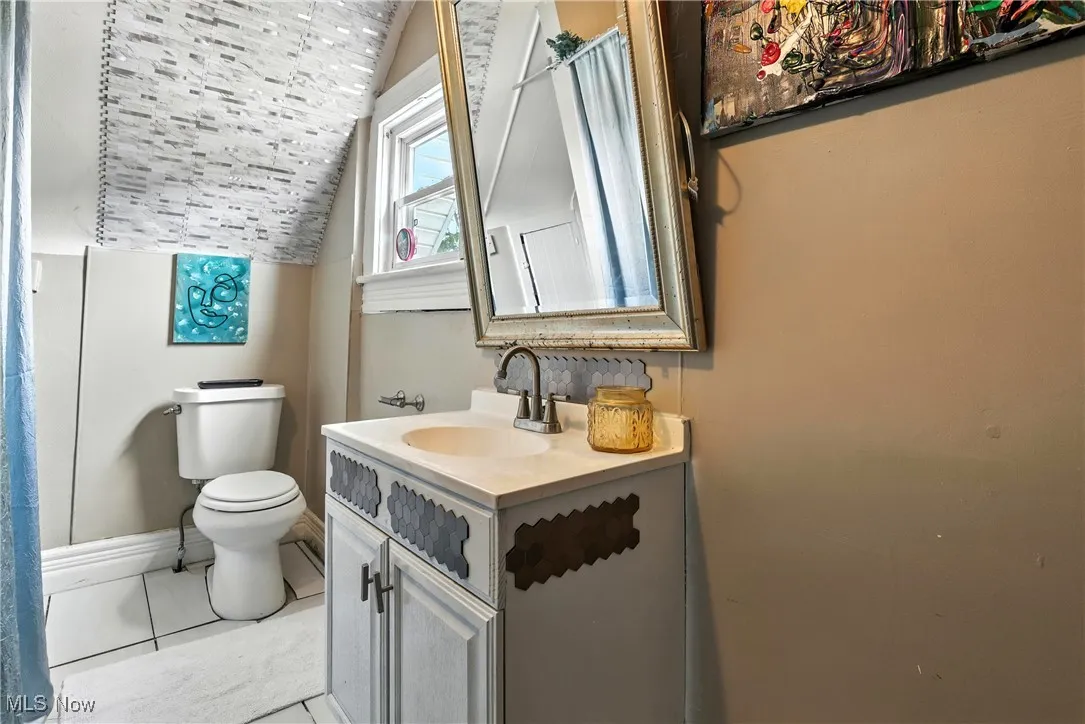 Bathroom featuring vanity and vaulted ceiling