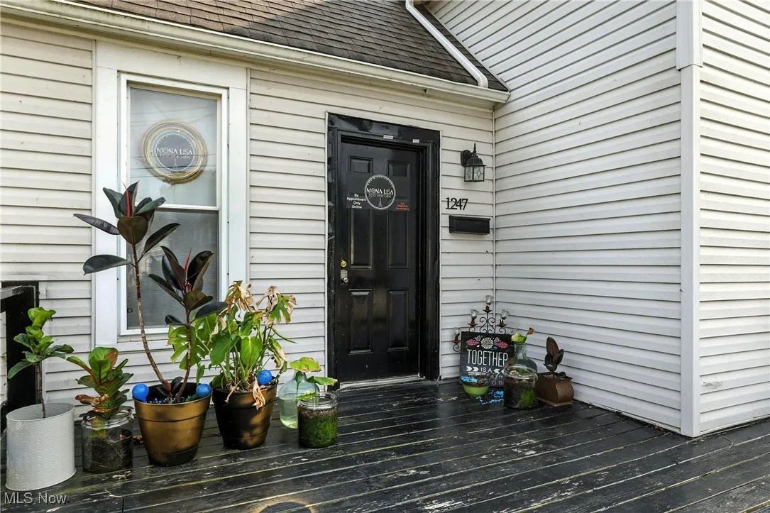 View of exterior entry with roof with shingles