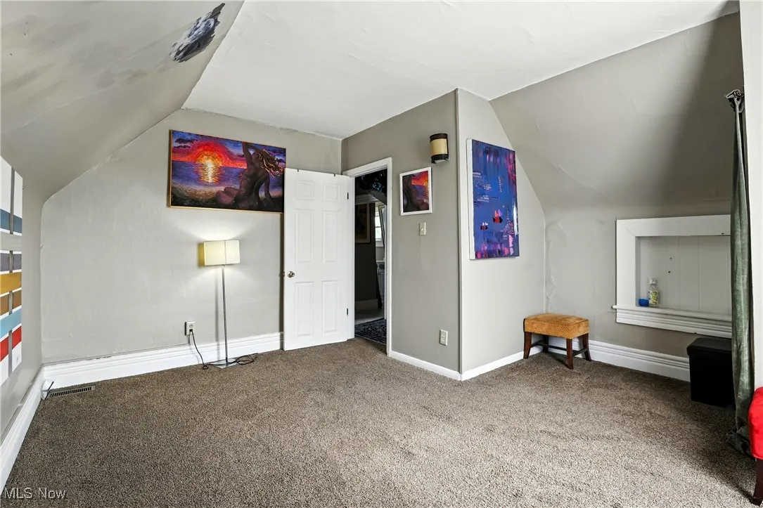 Bonus room with vaulted ceiling and carpet