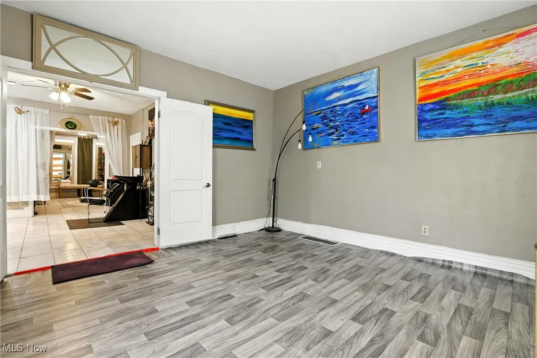 Empty room with a ceiling fan and light wood-type flooring