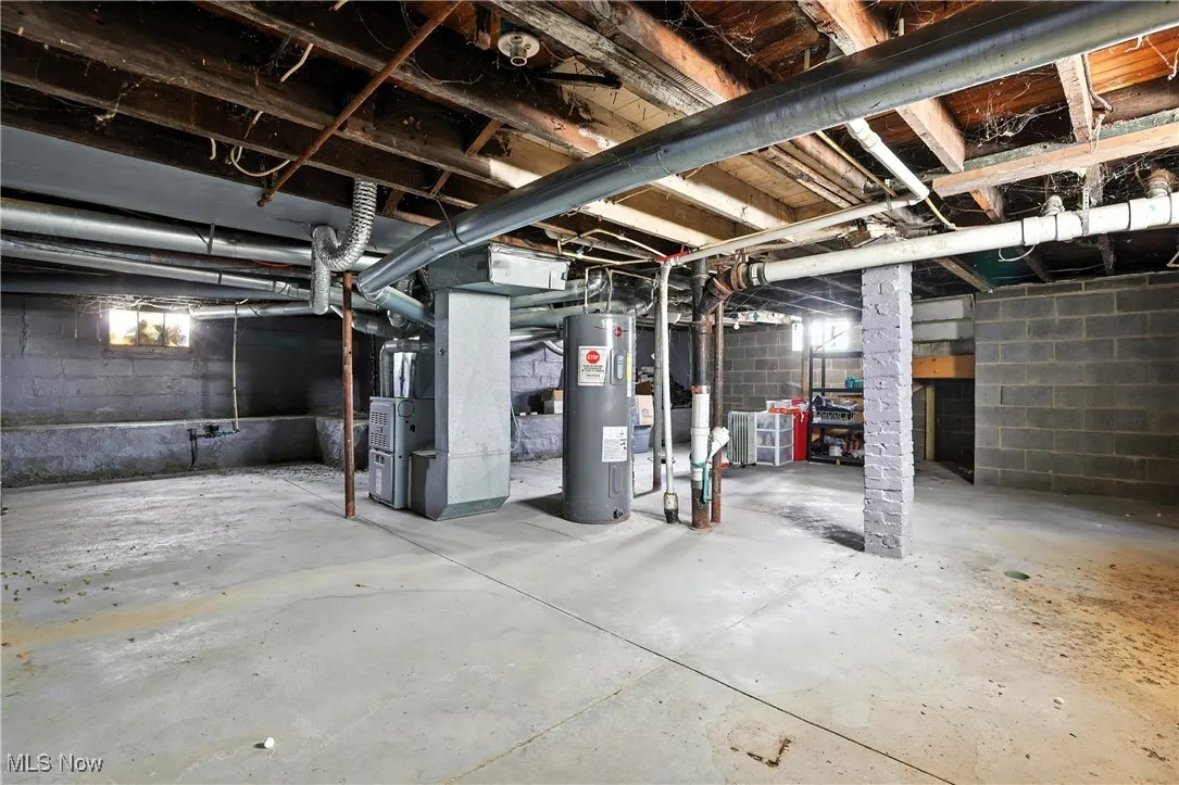 Unfinished basement featuring water heater and heating unit