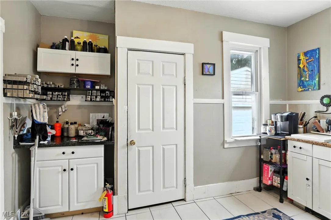 Kitchen featuring white cabinetry and light tile patterned flooring