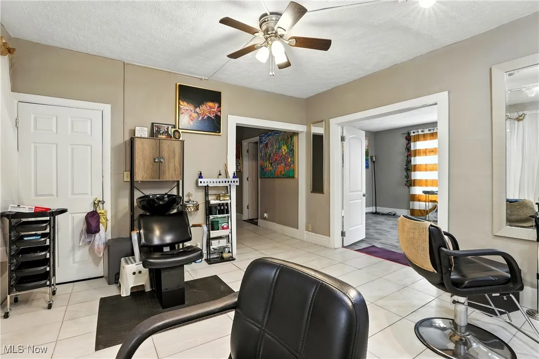 Office featuring a ceiling fan, a textured ceiling, and light tile patterned floors
