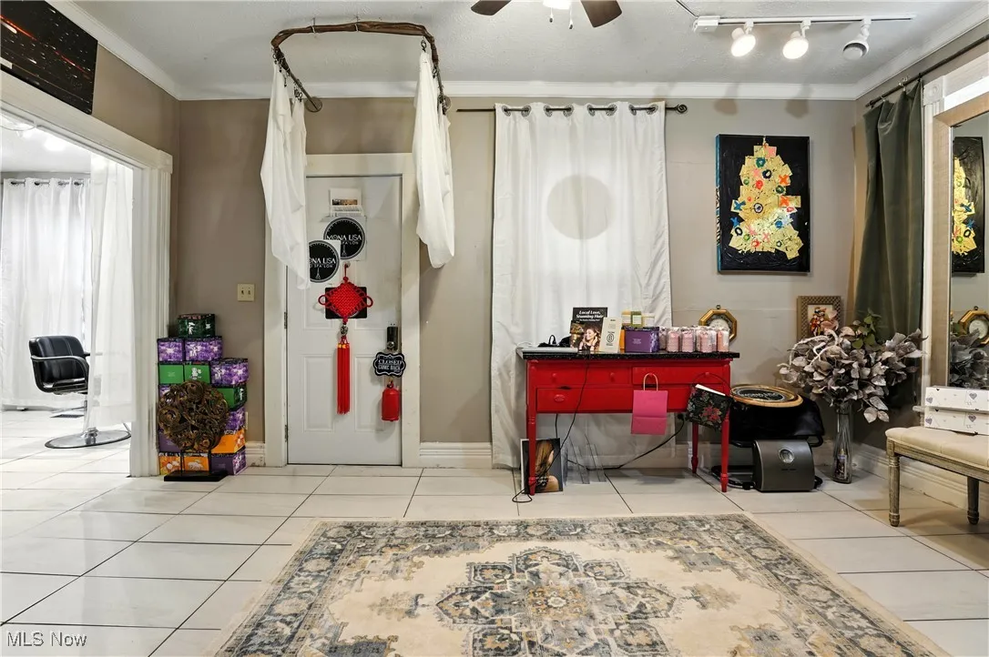 Foyer entrance with tile patterned floors and ceiling fan