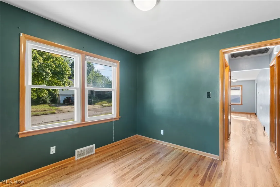 Empty room featuring wood finished floors and attic access