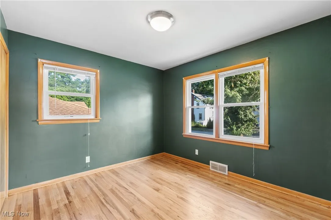 Empty room with healthy amount of natural light and wood finished floors