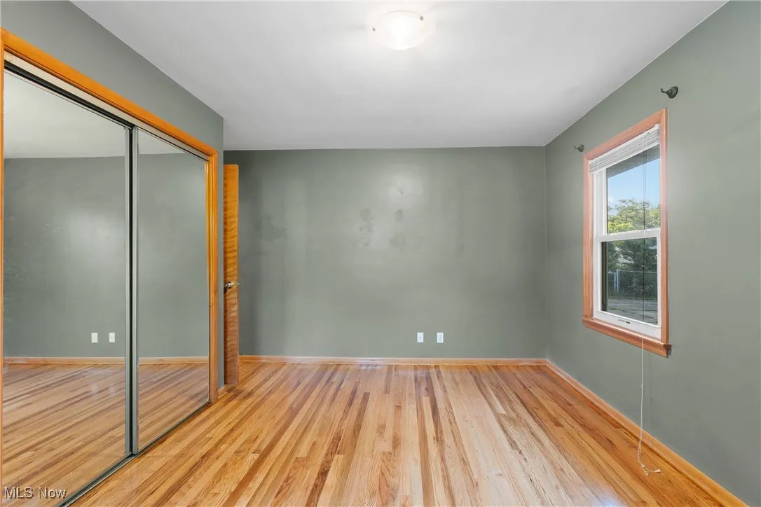 Unfurnished bedroom featuring wood finished floors and a closet