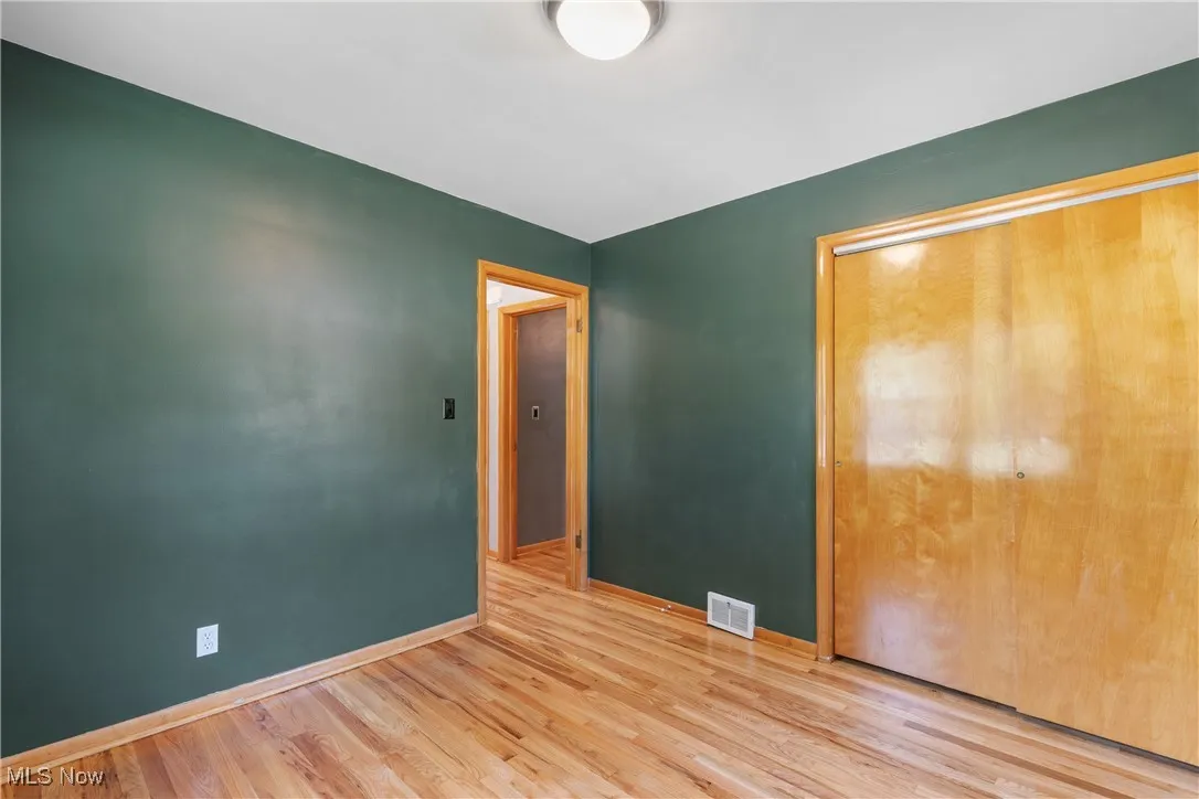 Unfurnished bedroom with wood finished floors and a closet
