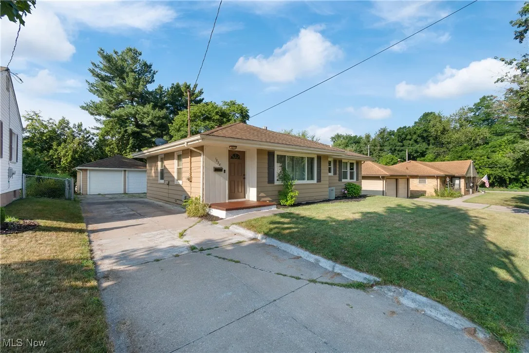 Bungalow-style home with an outdoor structure, a front yard, and a garage