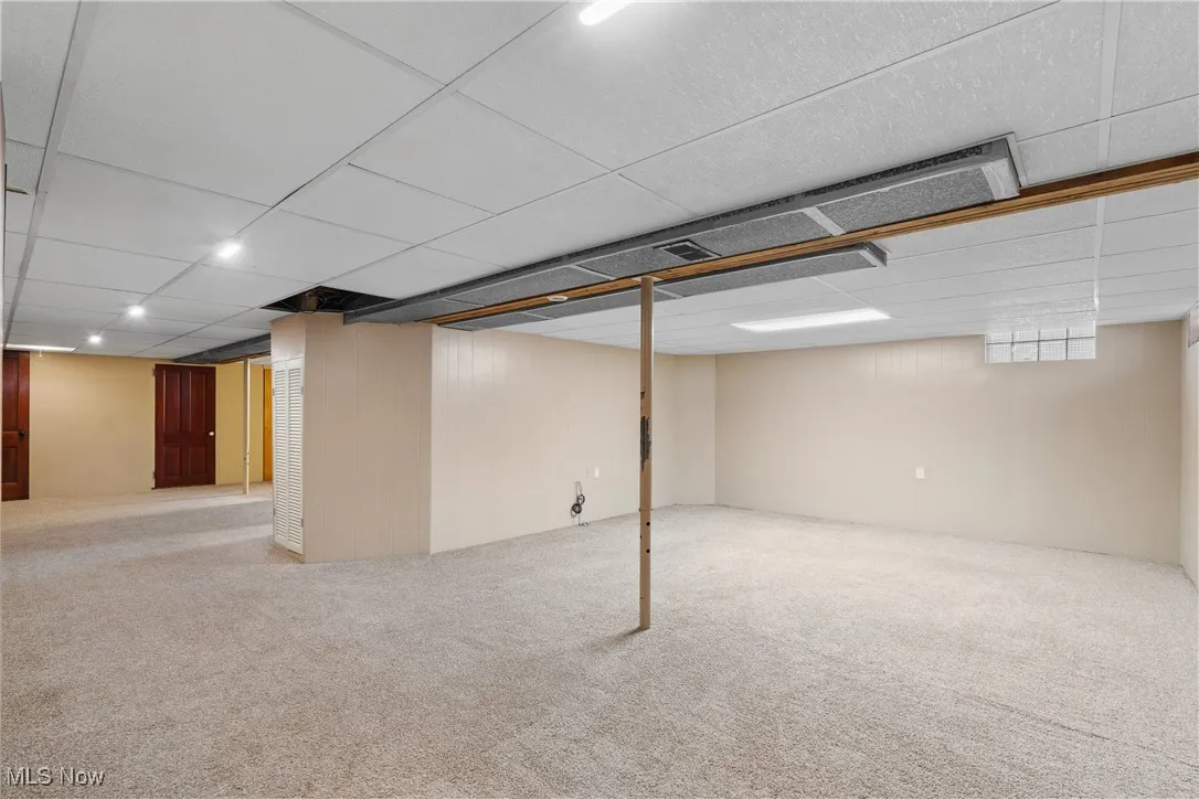 Basement with carpet floors and a drop ceiling
