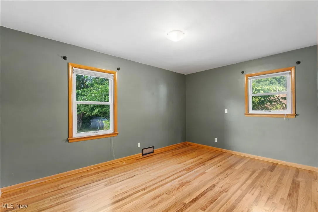 Spare room featuring plenty of natural light and wood finished floors