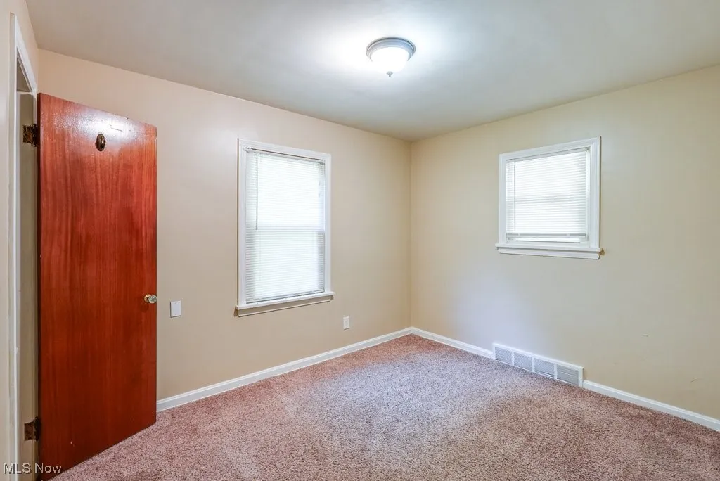Empty room featuring carpet floors and healthy amount of natural light
