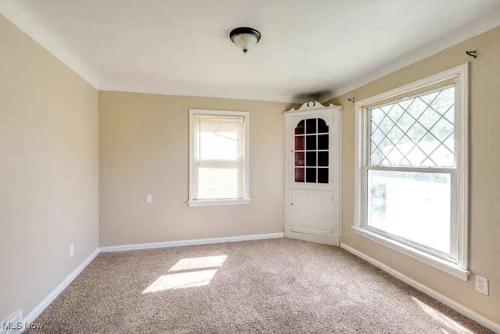 Carpeted empty room featuring plenty of natural light