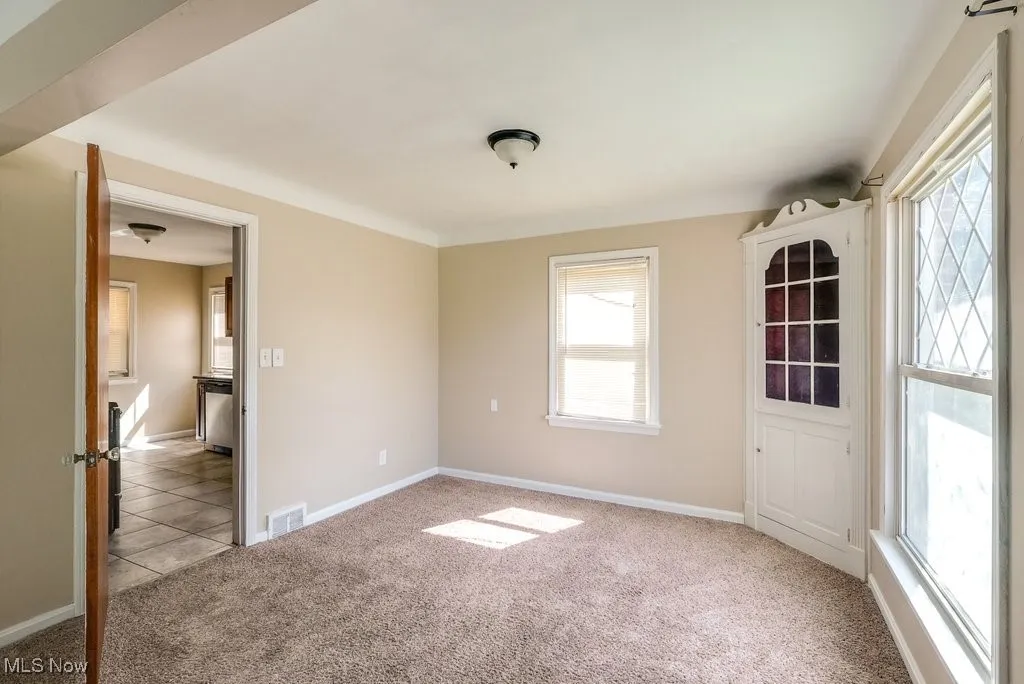 Carpeted spare room with baseboards