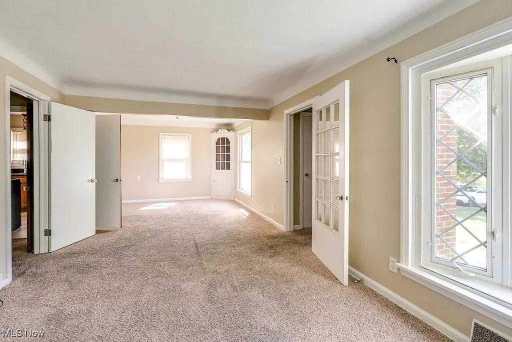 Spare room with light carpet and baseboards