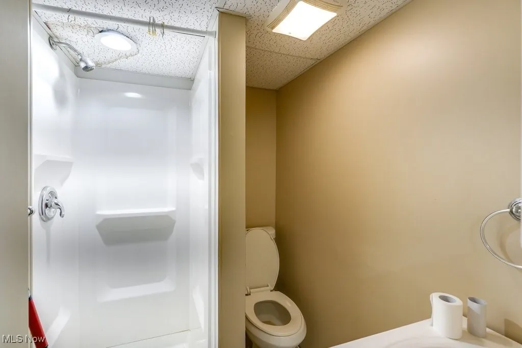 Bathroom featuring a shower and a drop ceiling
