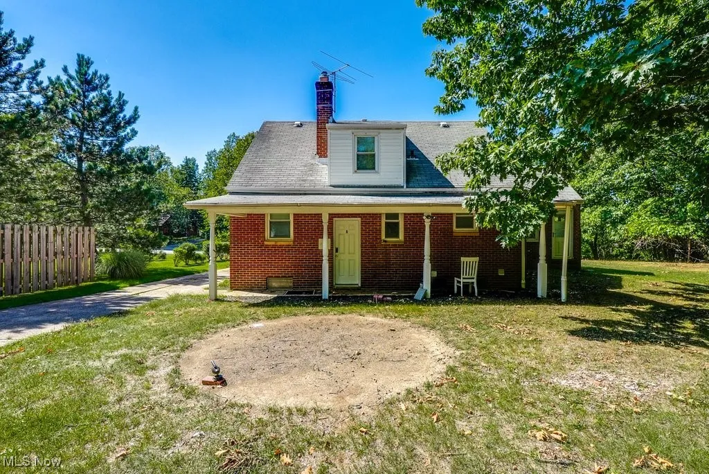 Rear view of property with a chimney and brick siding