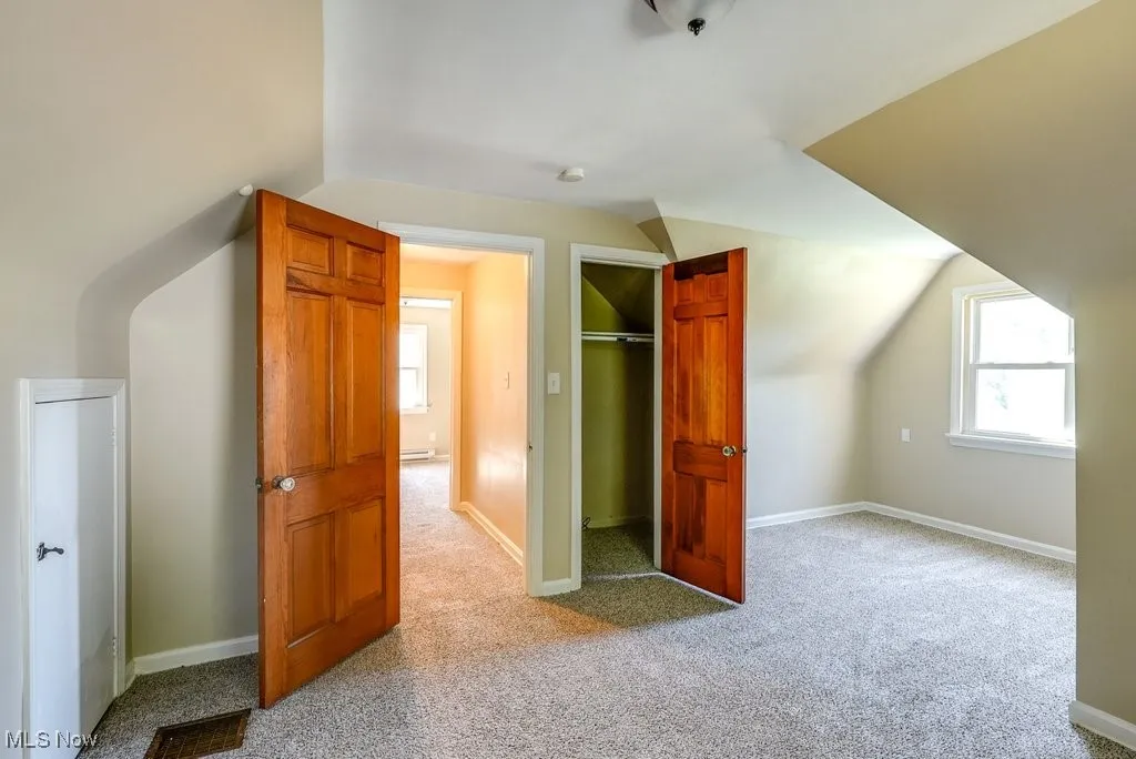 Additional living space featuring carpet floors and lofted ceiling