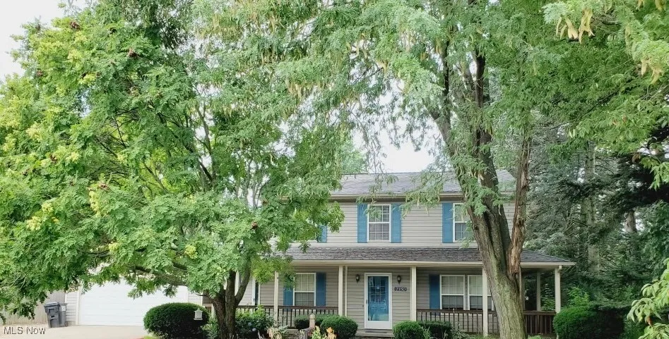 View of front of home featuring covered porch, driveway, a shingled roof, and an attached garage