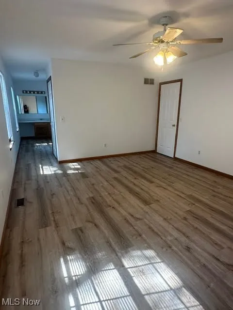 Primary Bedroom room with ceiling fan, wood finished floors, and healthy amount of natural light