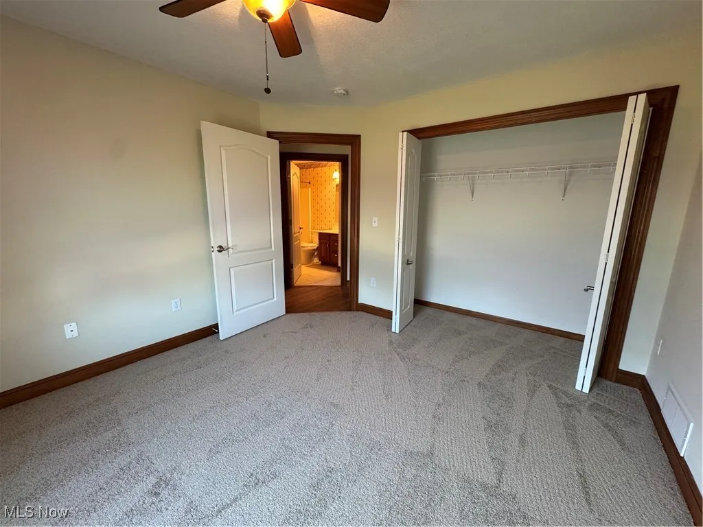 Unfurnished bedroom featuring carpet flooring, a closet, and ceiling fan