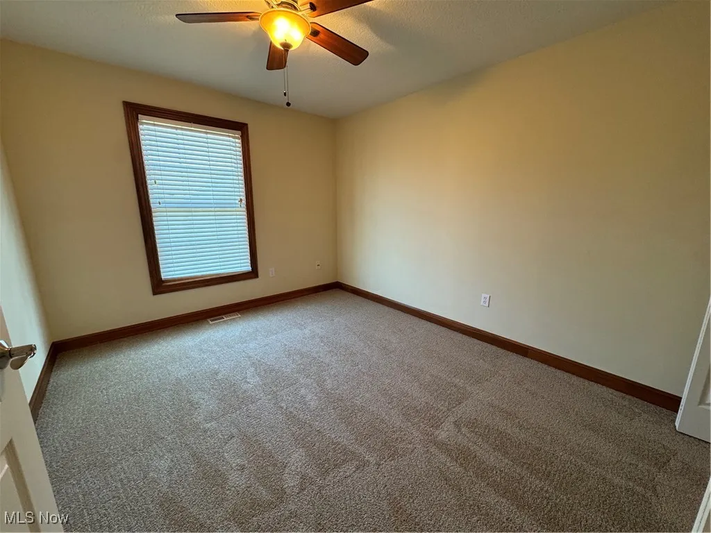 Spare room with carpet floors and ceiling fan