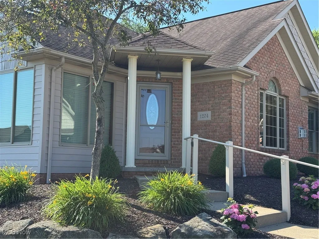 Entrance to property featuring roof with shingles