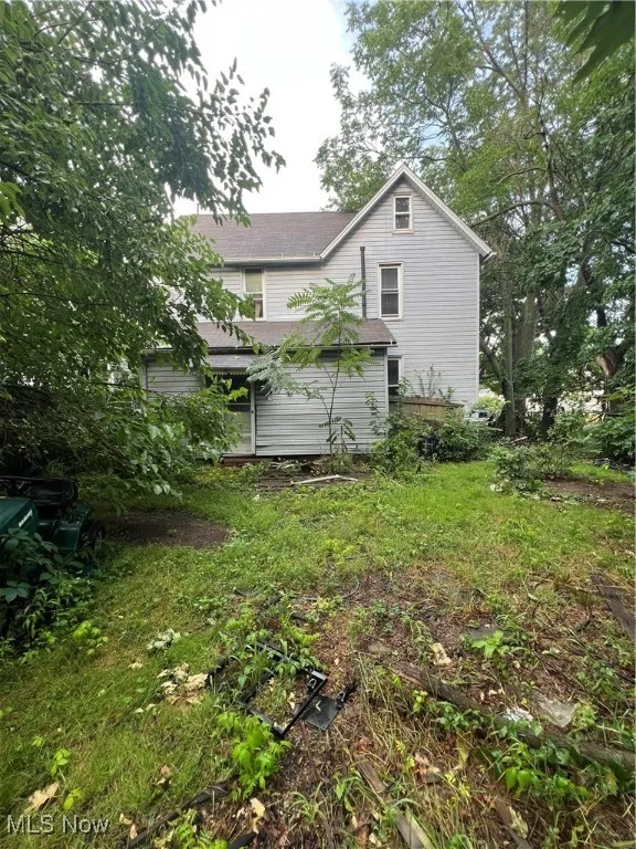 Back of property with a shingled roof