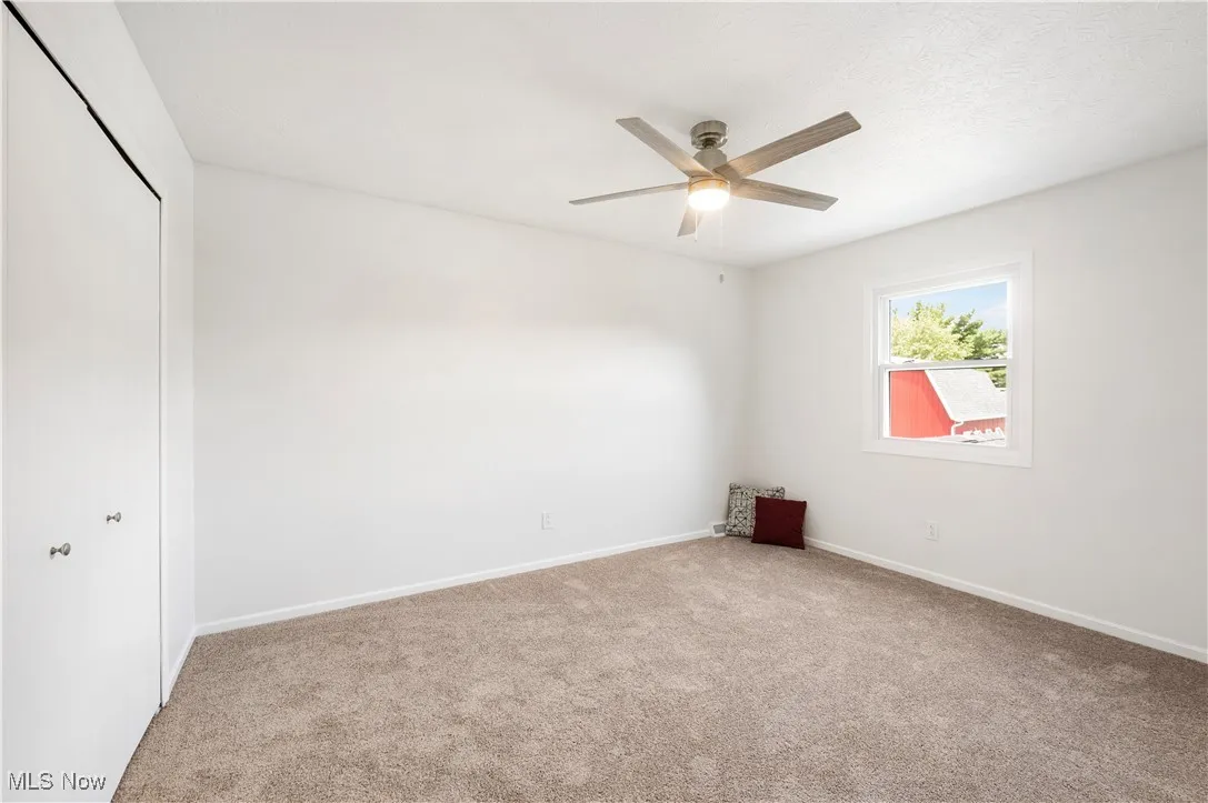 Unfurnished bedroom with carpet, a closet, and ceiling fan