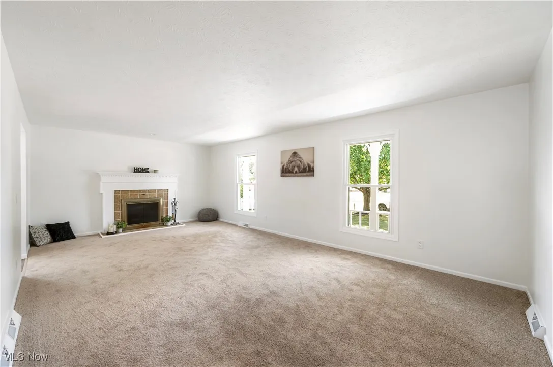 Unfurnished living room with carpet and a fireplace